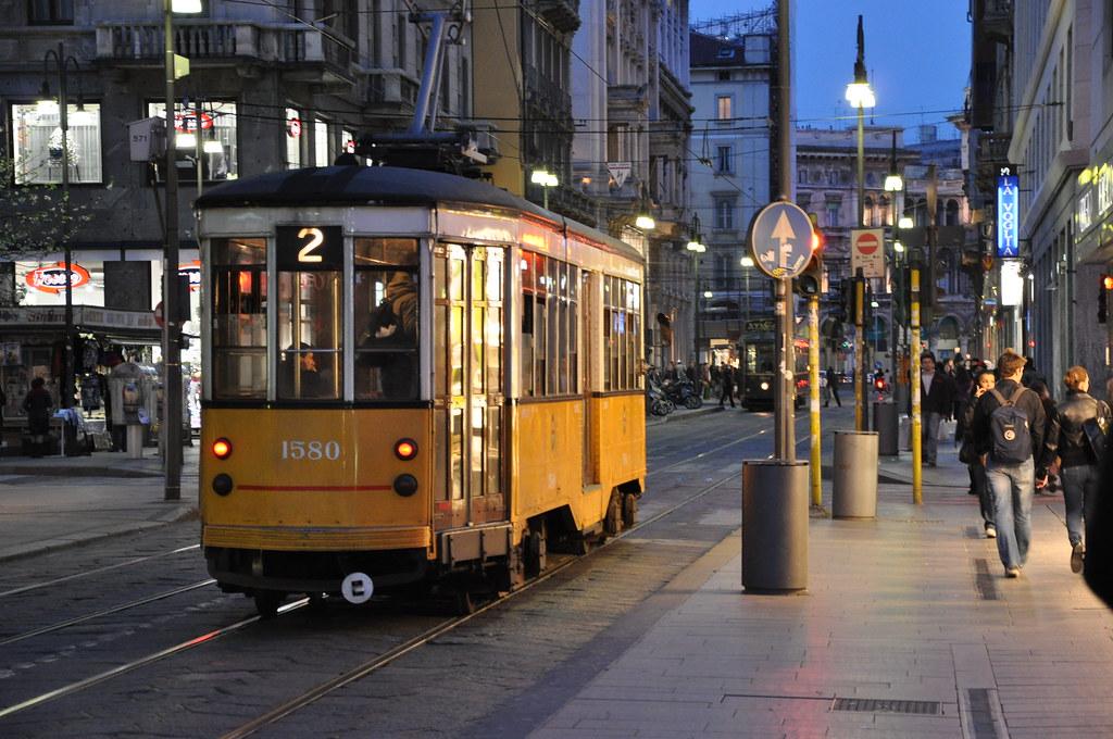 Un tram "carrelli" linea 2 nella tradizionale livrea bianco gialla in via Torino, visto da dietro, in una foto serale
Foto by Luca Riva
CC BY 2.0 
https://www.flickr.com/photos/50086990@N03/4752925689