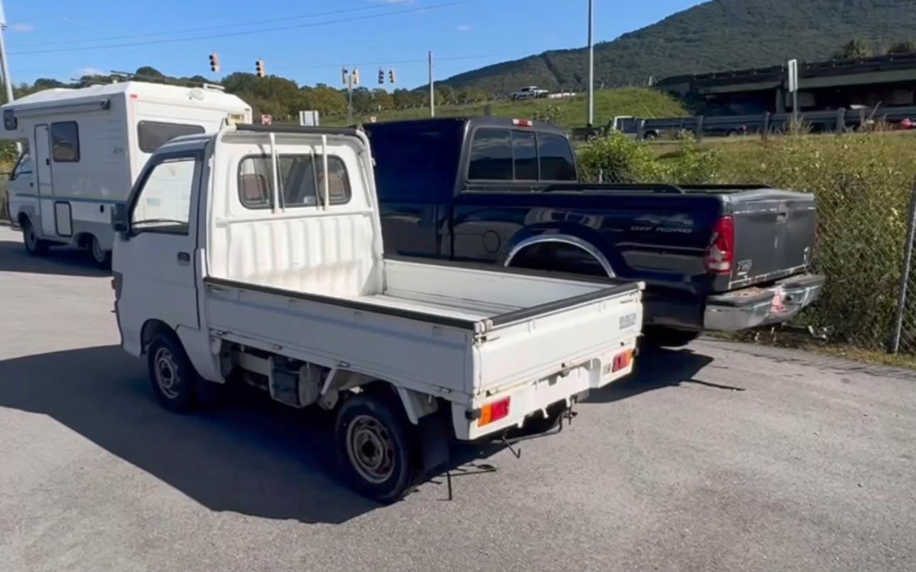 Foto di un kei truck giapponese accanto da un pickup americano in cui so vede che la capacità dei cassoni è simile